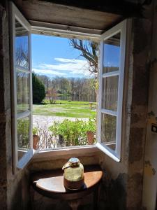 an open window with a table looking out at a field at Les Vergnes in Saint-Pardoux-le-Neuf