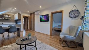 a living room with a clock on the wall at Apartmán Art in Zuberec