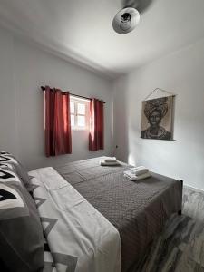 a bedroom with a large bed with red curtains at Grecos in Perissa
