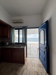 an open door to a kitchen with a view of the ocean at Grecos in Perissa