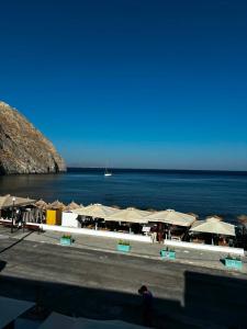 a beach with a bunch of umbrellas and the ocean at Grecos in Perissa
