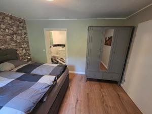 a bedroom with a bed and a stone wall at Ferienwohnung Talblick in Schmallenberg +20 photos