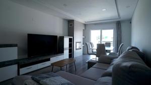 a living room with a couch and a flat screen tv at Moradia T4 Fernão Ferro in Fernao Ferro