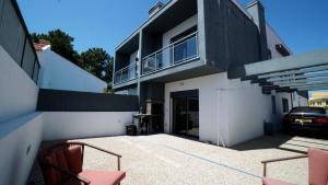 a house with a balcony with a car parked in it at Moradia T4 Fernão Ferro in Fernao Ferro