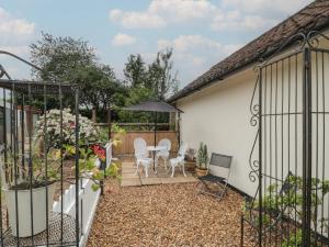 a patio with a table and chairs and an umbrella at Little Herriotts in Bristol