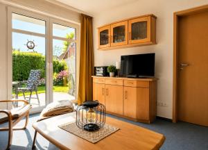 a living room with a table and a tv at FeWo kleine Auszeit in Cuxhaven