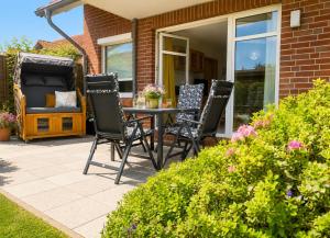 a patio with chairs and a table on a house at FeWo kleine Auszeit in Cuxhaven +17 photos