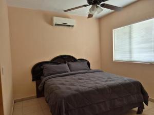 a bedroom with a bed with a ceiling fan at Bugambilias Terrazas in San Felipe +20 photos