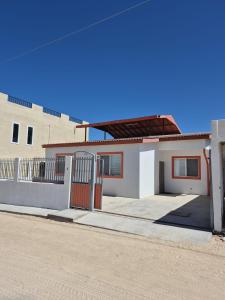 a white house with a gate and a building at Bugambilias Terrazas in San Felipe