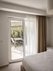 a bedroom with a bed and a patio with a table at White Arches in Ulcinj