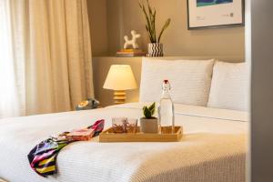a tray with a bottle and glasses on a bed at INNSiDE by Meliá Mexico Roma Norte in Mexico City