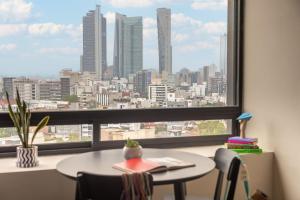 a table and chairs in a room with a large window at INNSiDE by Meliá Mexico Roma Norte in Mexico City