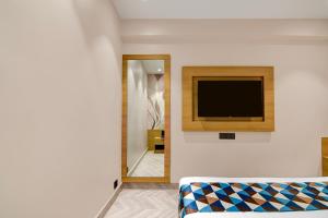a living room with a tv on a wall at Morya Villa - A Boutique Hotel in kolkata