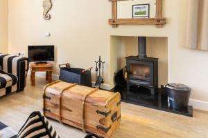 a living room with a fireplace and a stove at Saltkettle Sanctuary, Blakeney By Together Travel in Blakeney