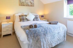a bedroom with a bed and two night stands at Saltkettle Sanctuary, Blakeney By Together Travel in Blakeney