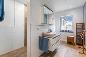 a white bathroom with a sink and a mirror at Hof Wuushöh in Stolk +35 photos