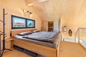 a bed in a wooden room with a window at Tiny House in Pischelsdorf am Engelbach
