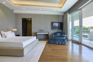 a bedroom with a bed and a tv and a chair at Adriatic Istria Resort by Minor Hotels in Savudrija
