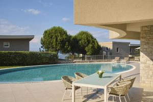 a table and chairs next to a swimming pool at Adriatic Istria Resort by Minor Hotels in Savudrija +99 photos