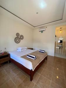 a bedroom with a bed with two towels on it at Gili Glow Homestay in Gili Trawangan