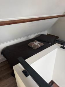 a bed in a small room with a black bedsheet at Het Atelier Schuring - Luxe vakantiehuis 78m2 in Numansdorp