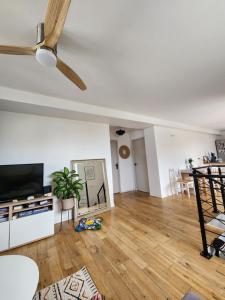 a living room with a ceiling fan and a wooden floor at Chambre chez Rena in Saint-Jean-de-Luz