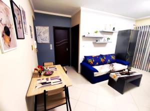 a living room with a blue couch and a table at CS apartment Patra in Patra +18 photos