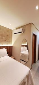 a bedroom with a bed and a mirror at Chale Praia Barrinha in Barrinha