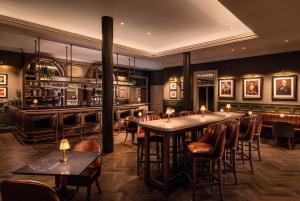 a restaurant with tables and chairs and a bar at The Bedford Hotel Belfast in Belfast