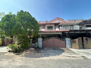 a house with a red gate and a tree at Fairuz Homestay Ipoh in Ipoh