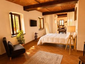 a bedroom with a bed and a chair and a table at Country Loft Colle Miroteo in Monforte dʼAlba