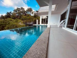 an infinity pool in the backyard of a house at White Villa Lanta in Ko Lanta