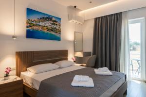 a bedroom with a bed with two towels on it at Aimilia Boutique Studio Kalathos in Kalathos