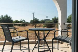 a table and chairs on a balcony with a view of train tracks at Aimilia Boutique Studio Kalathos in Kalathos +4 photos