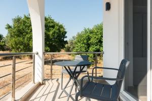 a patio with a table and chairs on a porch at Aimilia Boutique Studio Kalathos in Kalathos