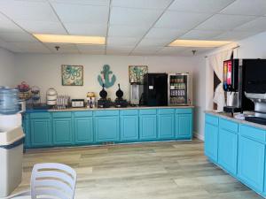 a kitchen with blue cabinets and a counter at The Islander Inn in Ocean Isle Beach