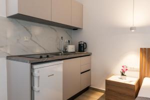 a kitchen with white cabinets and a counter top at Aimilia Boutique Studio Kalathos in Kalathos