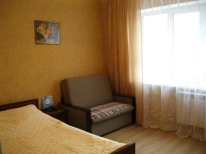 ヴェリーキー・ノヴゴロドにあるApartment Volotovskaya 6のベッドルーム(椅子、窓付)