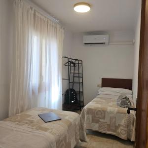 a bedroom with two beds next to a window at Cosy Apartament Figueres in Figueres +23 photos