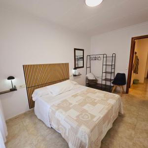 a bedroom with a bed and a chair and a ladder at Cosy Apartament Figueres in Figueres