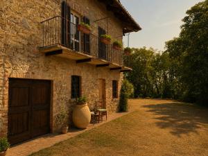 a stone building with a balcony and a door at Country Loft Colle Miroteo in Monforte dʼAlba