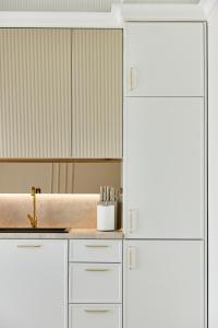 a kitchen with white cabinets and a sink at Apartamenty Topollino in Częstochowa +177 photos