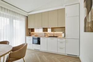 a kitchen with white cabinets and a table at Apartamenty Topollino in Częstochowa