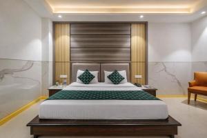 a bedroom with a large bed and a chair at Hotel ravan in New Delhi
