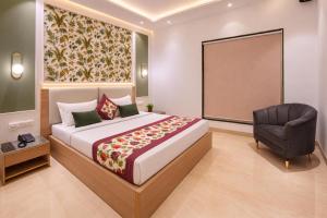 a bedroom with a large bed and a chair at Hotel ravan in New Delhi