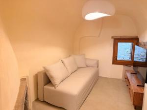 a white couch in a room with a window at Luxe Lane Kalamoti in Chios