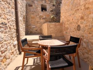 a wooden table and chairs on a patio at Luxe Lane Kalamoti in Chios