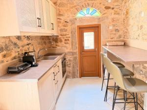 a kitchen with a sink and a counter with stools at Luxe Lane Kalamoti in Chios
