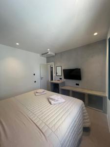 a bedroom with a white bed and a tv at Iconic Project Lagada in Amorgos