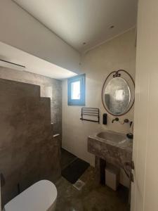 a bathroom with a sink and a toilet and a mirror at Iconic Project Lagada in Amorgos